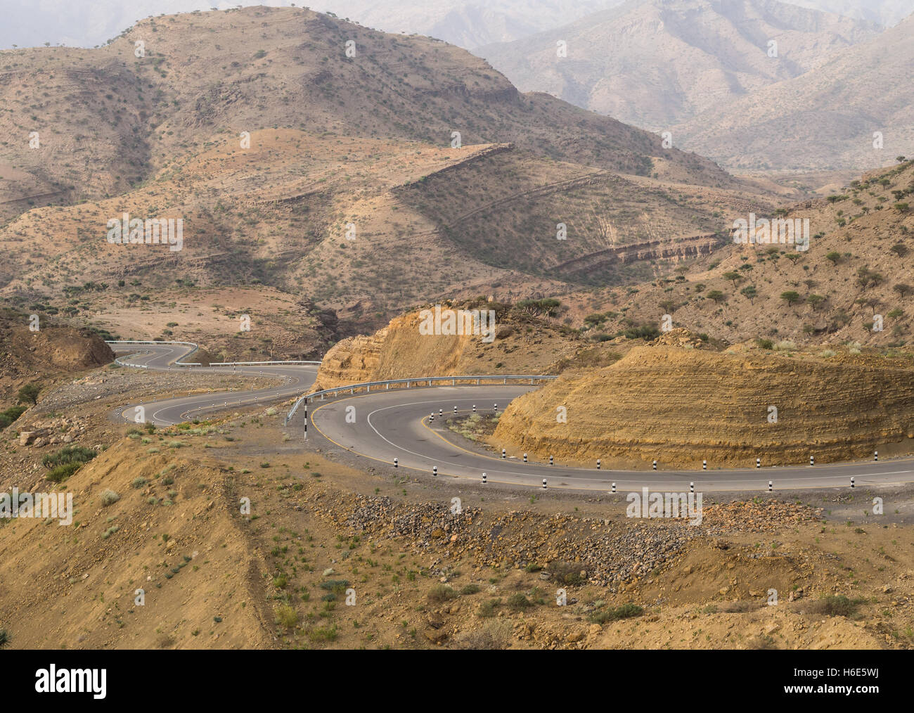 Strada che corre attraverso il paesaggio secco in Etiopia in luglio. Foto Stock