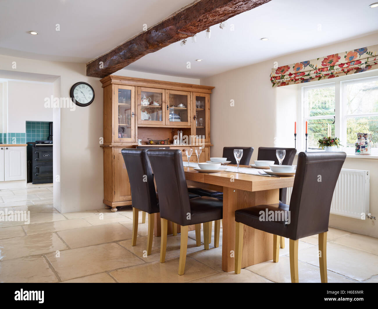 Un tavolo in legno di quercia impostato per 6 in una grande sala da pranzo adiacente alla cucina di una casa di campagna in Cotswolds, Gloucestershire, Regno Unito Foto Stock