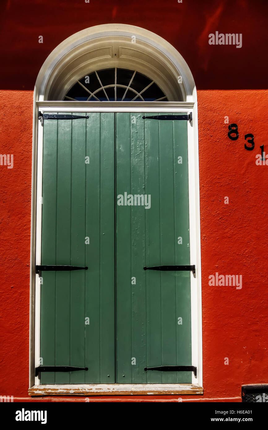 Sportello Verde o tapparelle su un edificio rosso nel Quartiere Francese di New Orleans Foto Stock