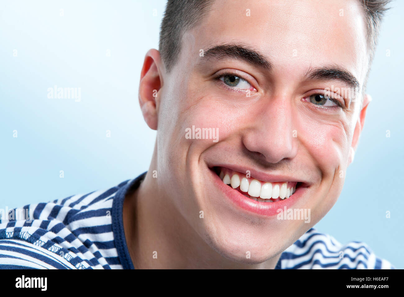 Macro volto ritratto del bel giovane uomo con i denti sani cercando da parte. Foto Stock