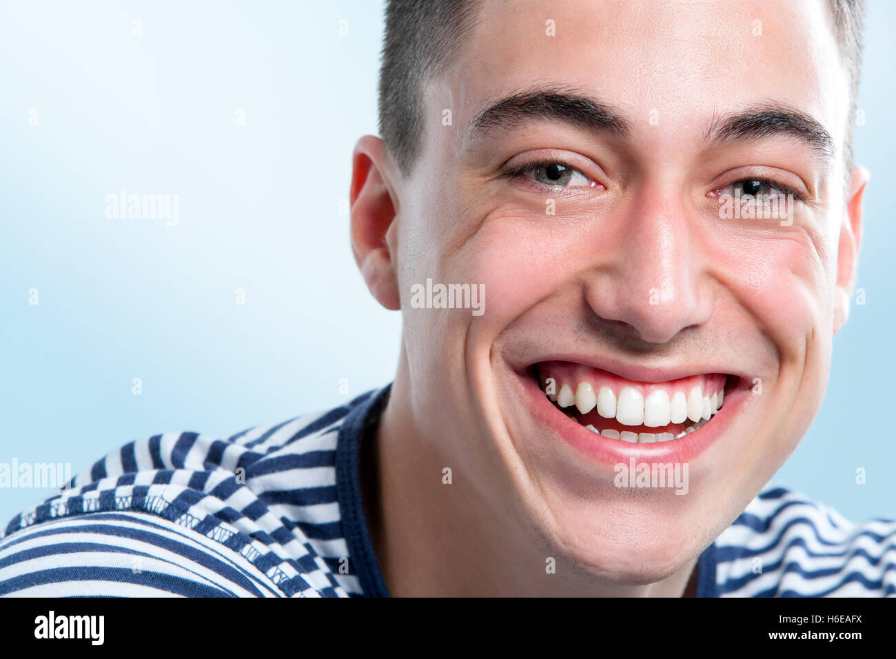 Extreme close up faccia colpo di giovane con affascinante e sano sorriso toothy. Foto Stock