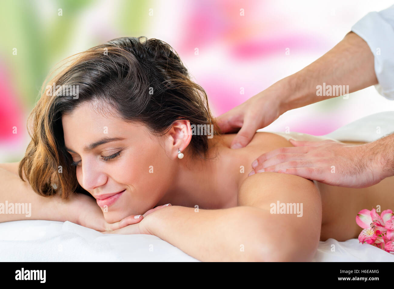 Close up della giovane donna attraente godendo di massaggio alla schiena. Terapista di massaggio mani sulle spalle e collo. Foto Stock