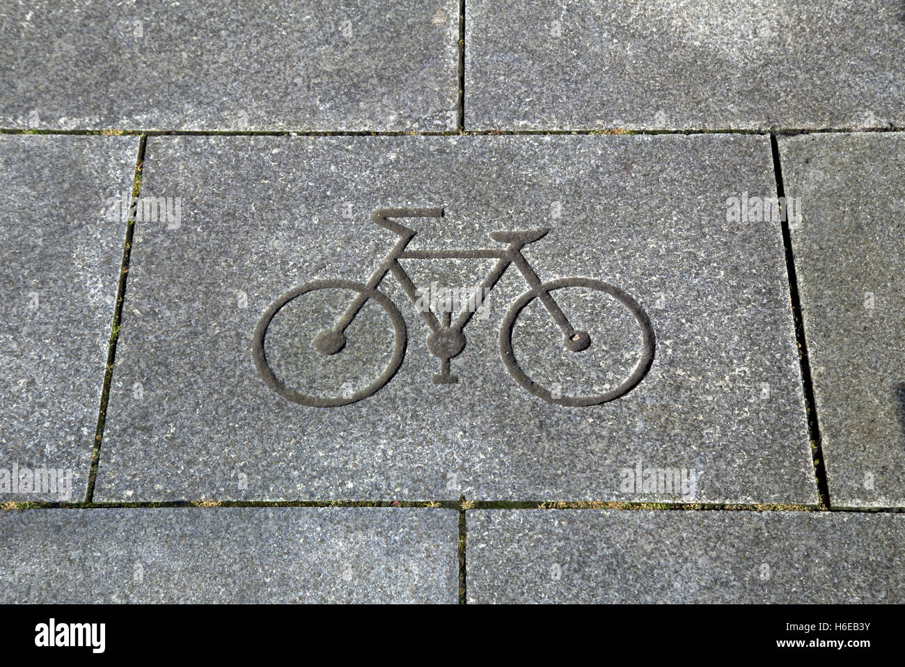 La bici o moto simbolo tagliato in una pavimentazione in pietra Foto Stock