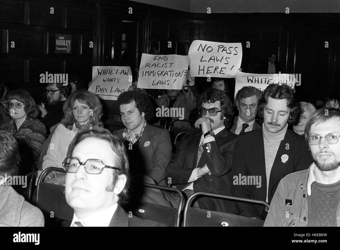 Targhetta-wielding manifestanti tra il pubblico quando il vice leader dei conservatori William Whitelaw - che la scorsa settimana ha introdotto il partito dei nuovi piani di rendere più rigorosi i controlli in materia di immigrazione - affrontato una riunione elettorale a Lambeth Town Hall di Brixton, Londra. Brixton, dove si stima che il 25% della popolazione è nero, è parte della centrale di Lambeth circoscrizione che va alle urne in aprile 20th. La elezione è stata causata dalla morte di Marcus Lipton, che ha la sede per la manodopera per 33 anni. PA AF 183862-6 Foto Stock