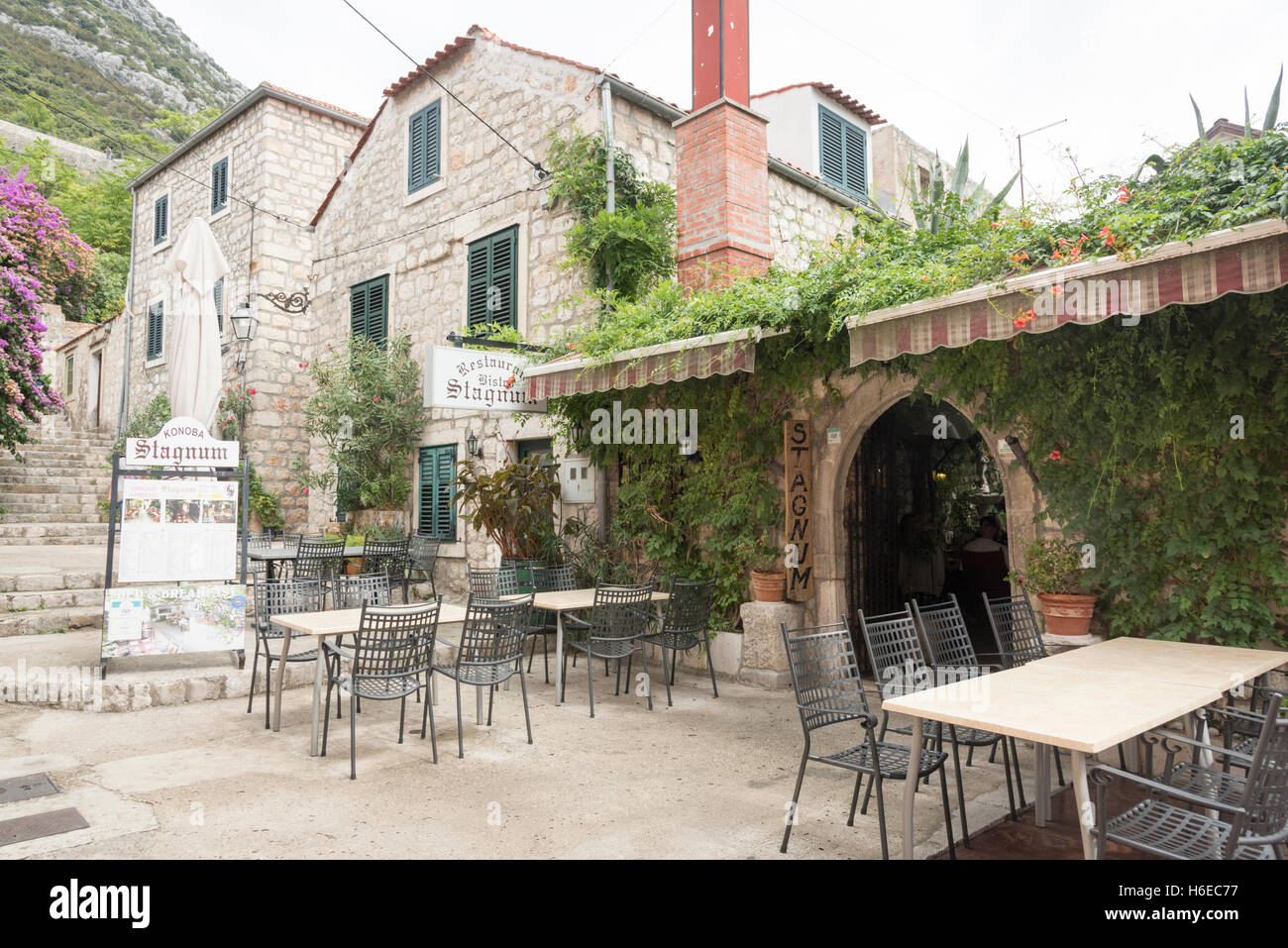 Il ristorante di pesce e frutti di mare in Stagnum Ston Croazia che mostra i tavoli fuori e la vite entrata coperta Foto Stock