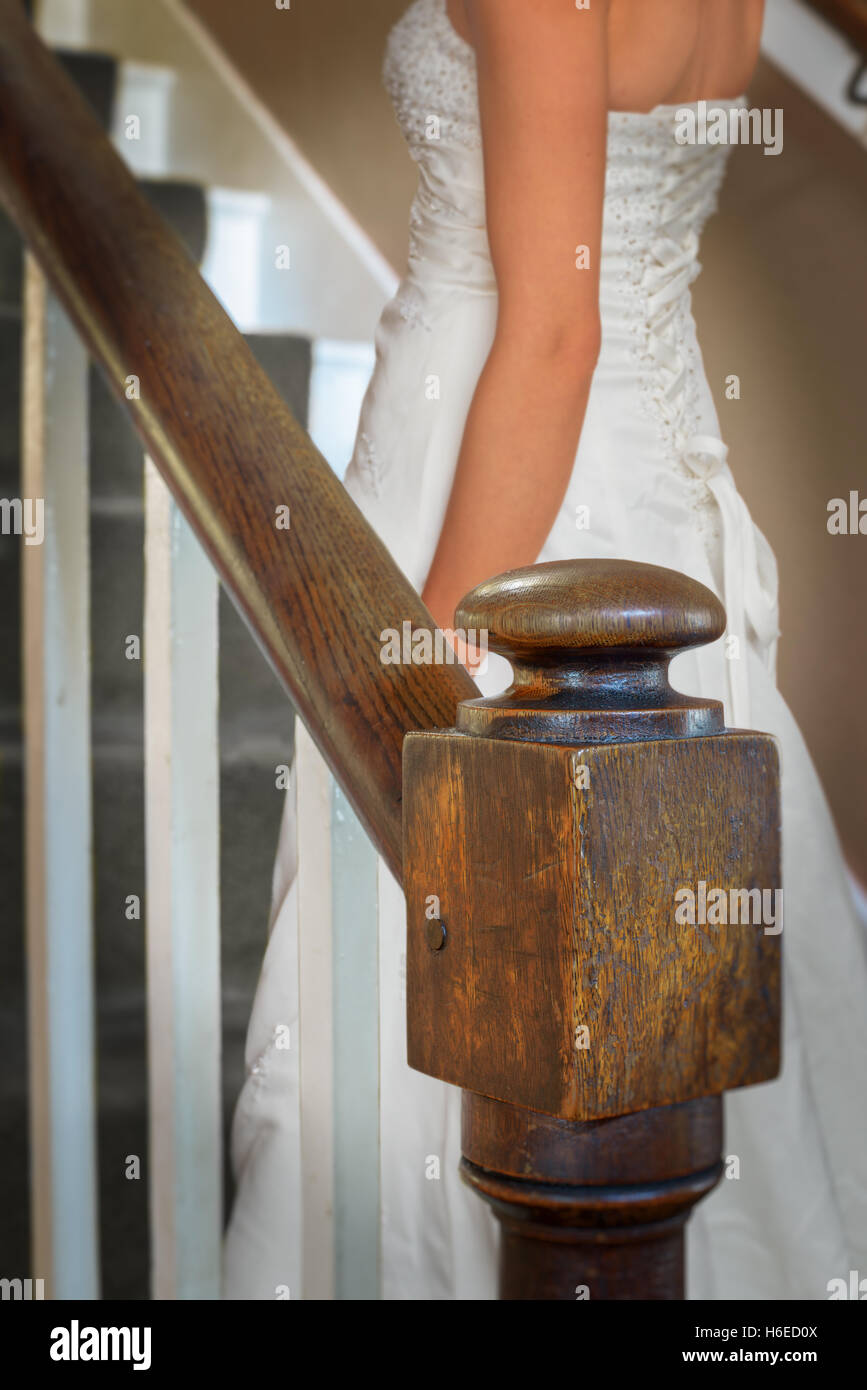 Sposa a camminare su vecchia scalinata in legno di quercia Foto Stock