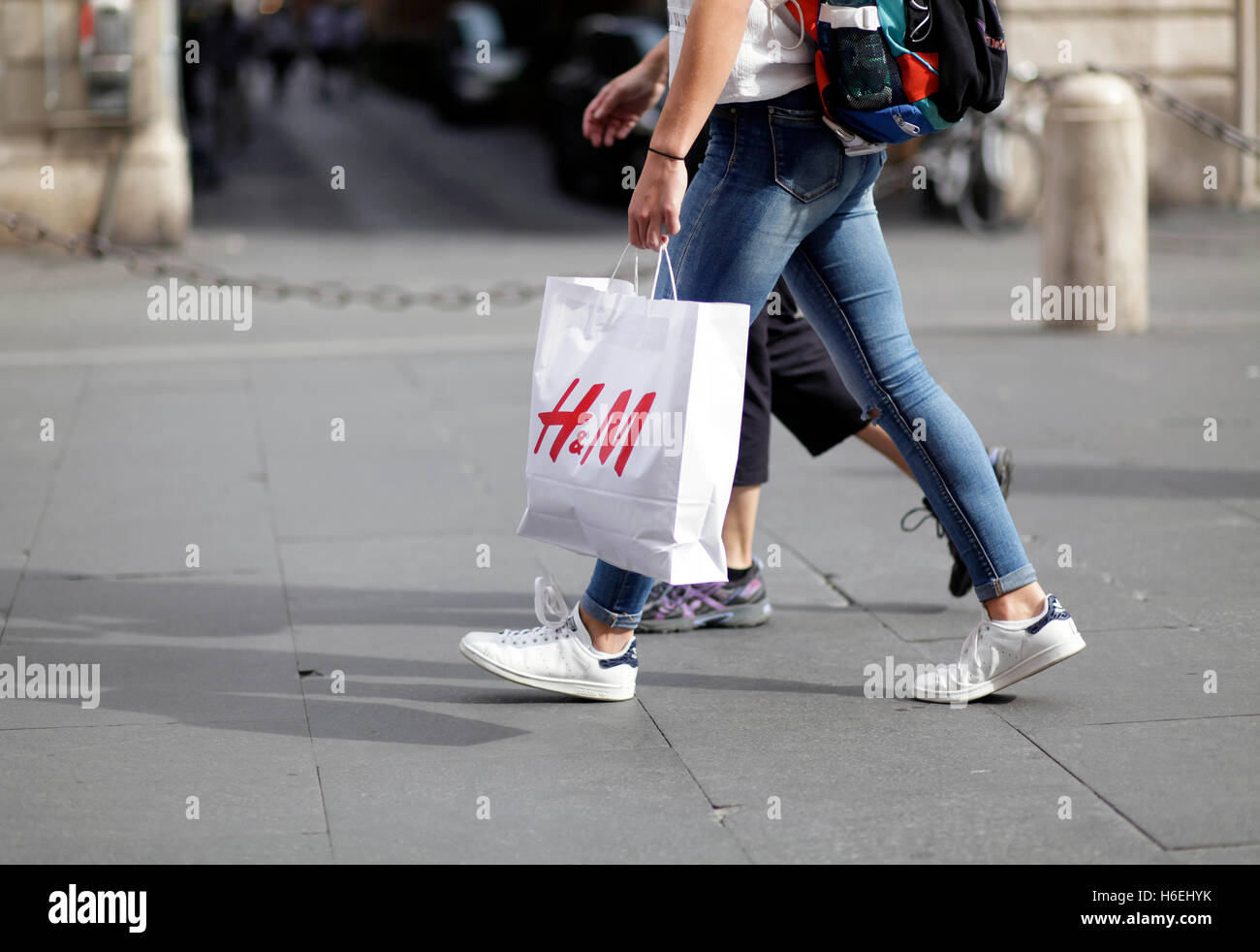 Passeggiate a piedi con il suo H&M borsa da shopping di Via del Corso, via  principale dello shopping a Roma, Italia Foto stock - Alamy