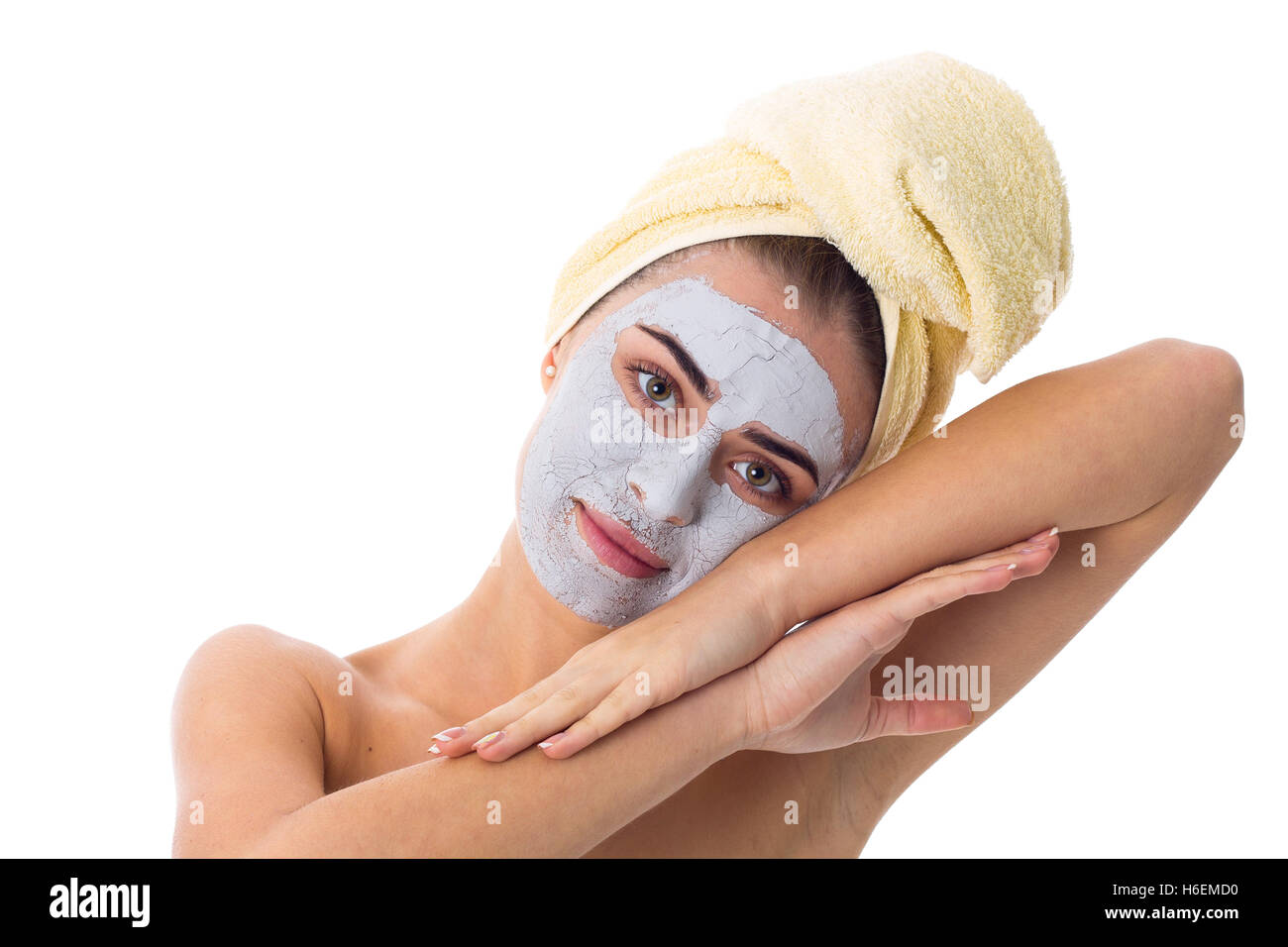 Donna con asciugamano sul suo capo e la maschera di cosmetici sul suo viso Foto Stock
