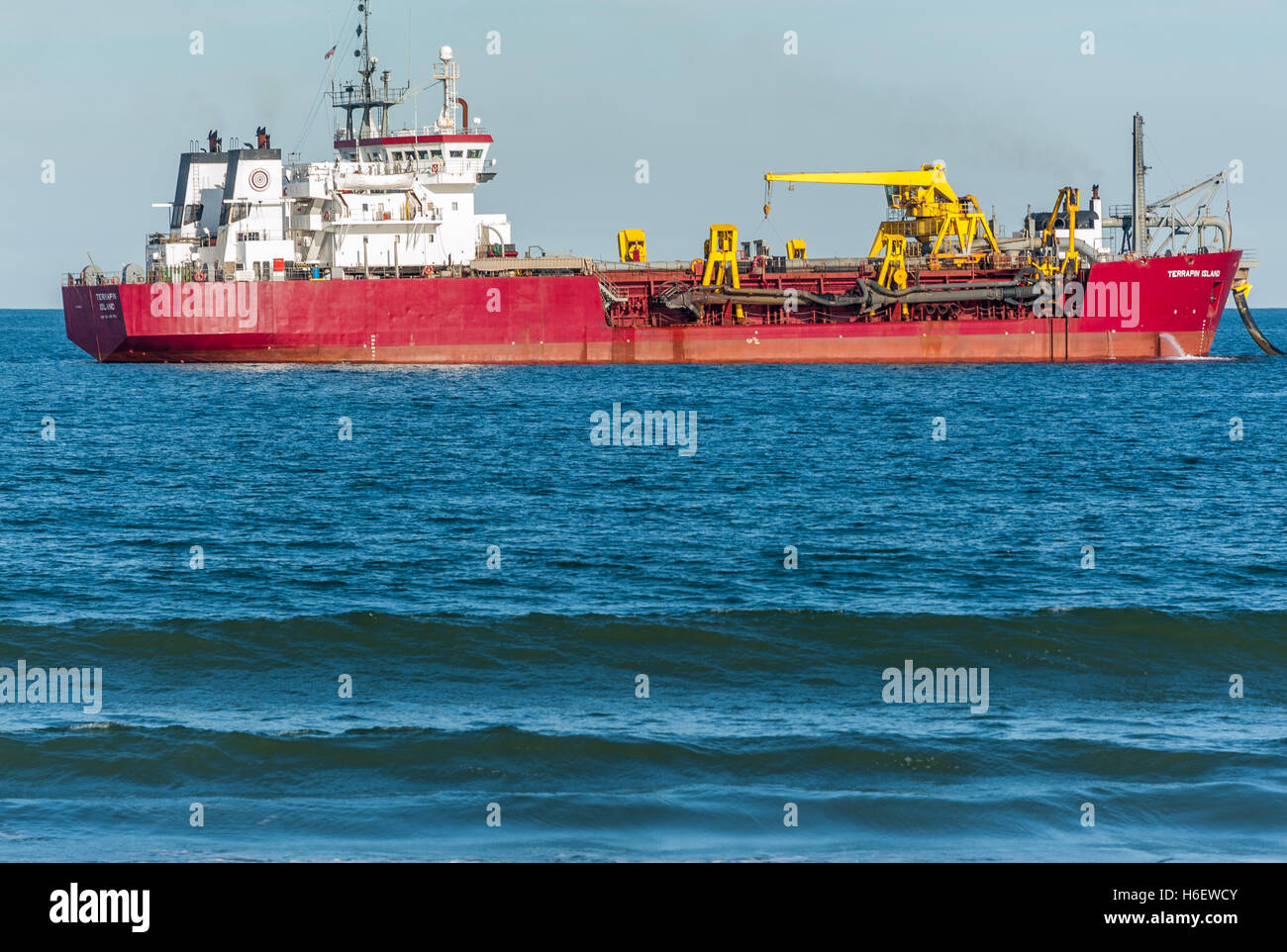 Una Draga si trova appena al largo lungo la spiaggia di Jacksonville sabbia di pompaggio per la spiaggia il restauro dopo l'uragano di Matteo di erosione. Foto Stock