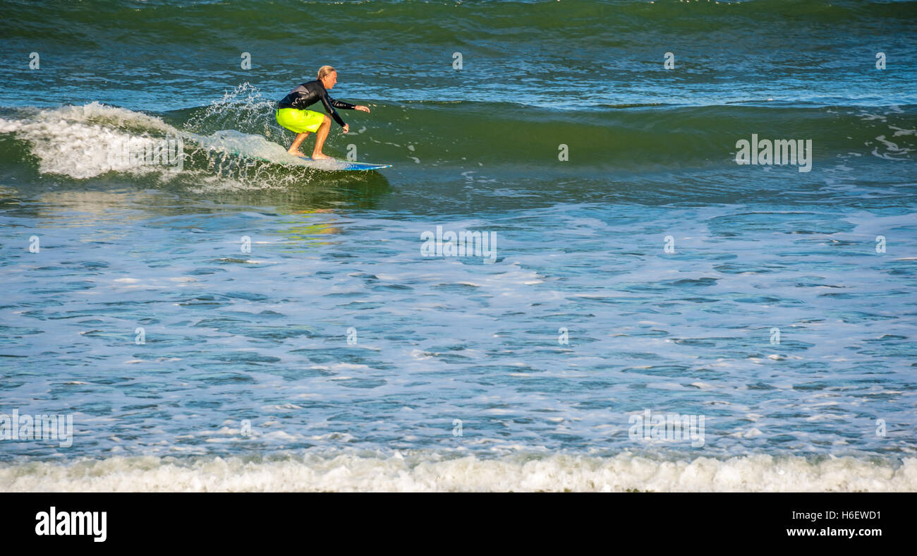 Surfer in sella a una lunga e pulita wave a Jacksonville Beach, Florida. (USA) Foto Stock
