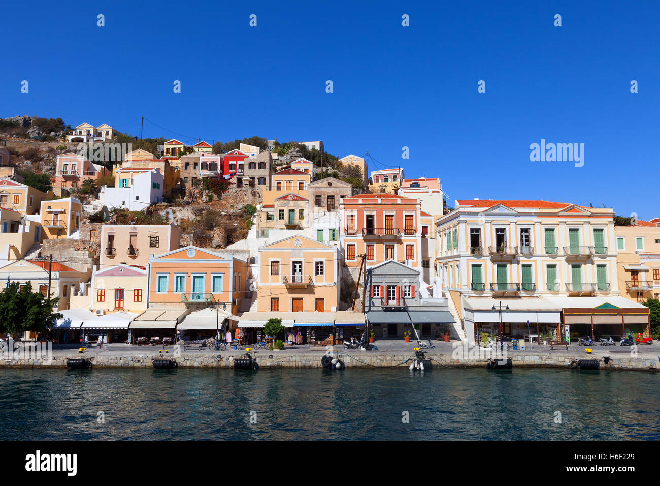 Symi island - case colorate e piccole imbarcazioni al cuore del villaggio Foto Stock