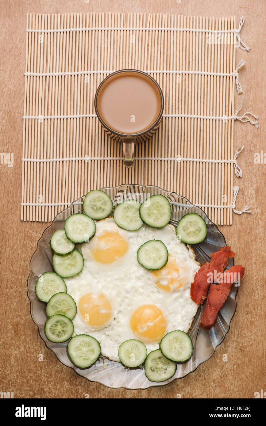 La prima colazione a base di uova strapazzate con verdure cetriolo, salmone affumicato, pesce e caffè. Superiore Vista laici Foto Stock