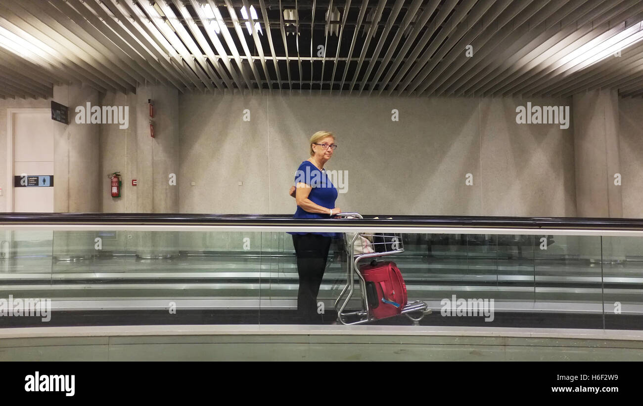 Una donna su un tapis roulants all'aeroporto di Palma di Maiorca. Foto Stock