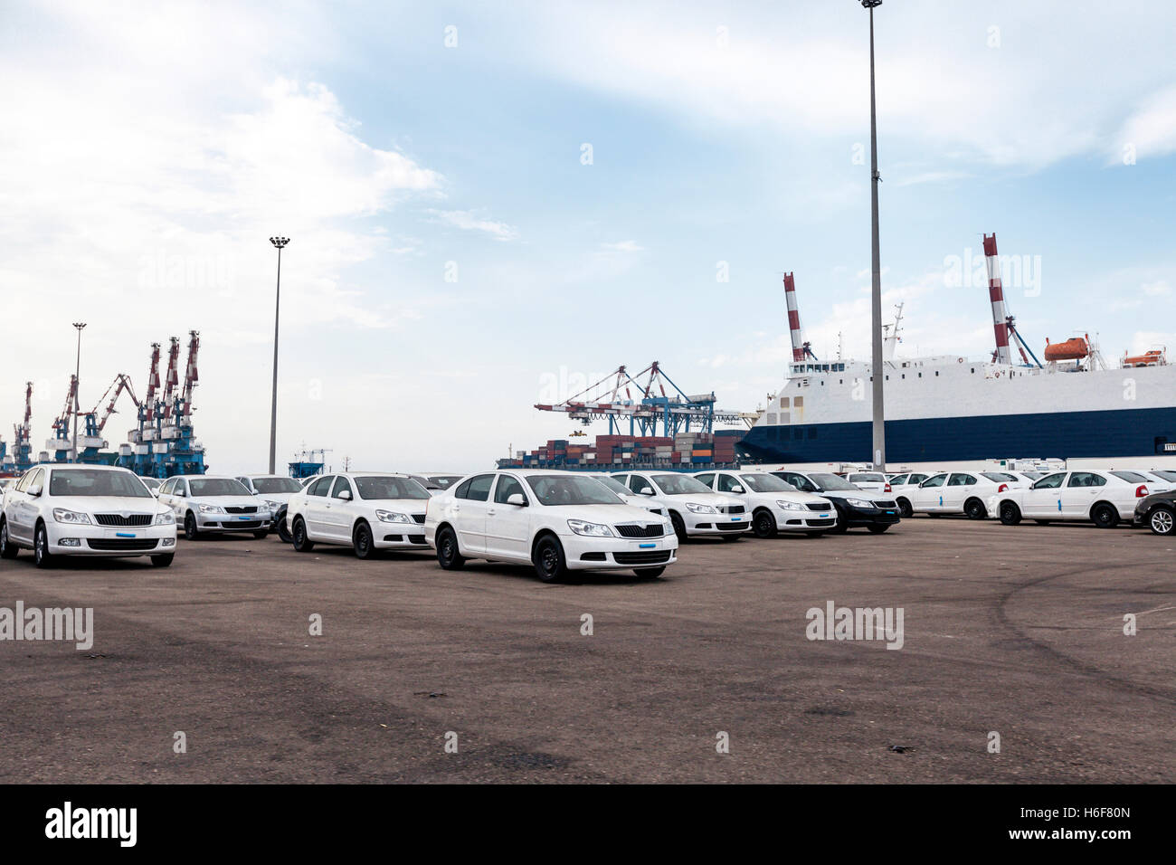Spazio parcheggio pieno con nuove vetture che era appena stato scaricato dalla macchina freighter al loro porto di arrivo. Foto Stock