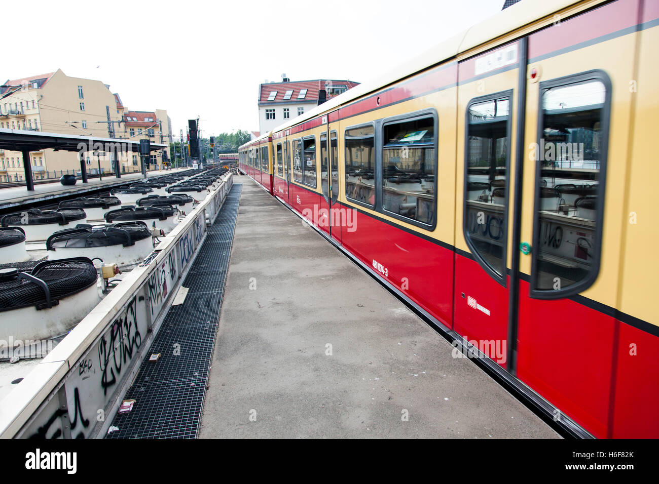 Treno in partenza un urbano stazione ferroviaria piattaforma in Berlino, con una lunga fila di ventilatori che fanno circolare l'aria per la undergr Foto Stock
