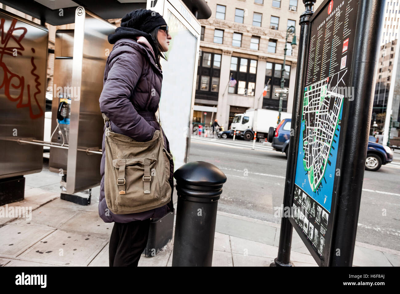Una donna adulta guardando la parte inferiore di Manhattan mappa stradale. Foto Stock