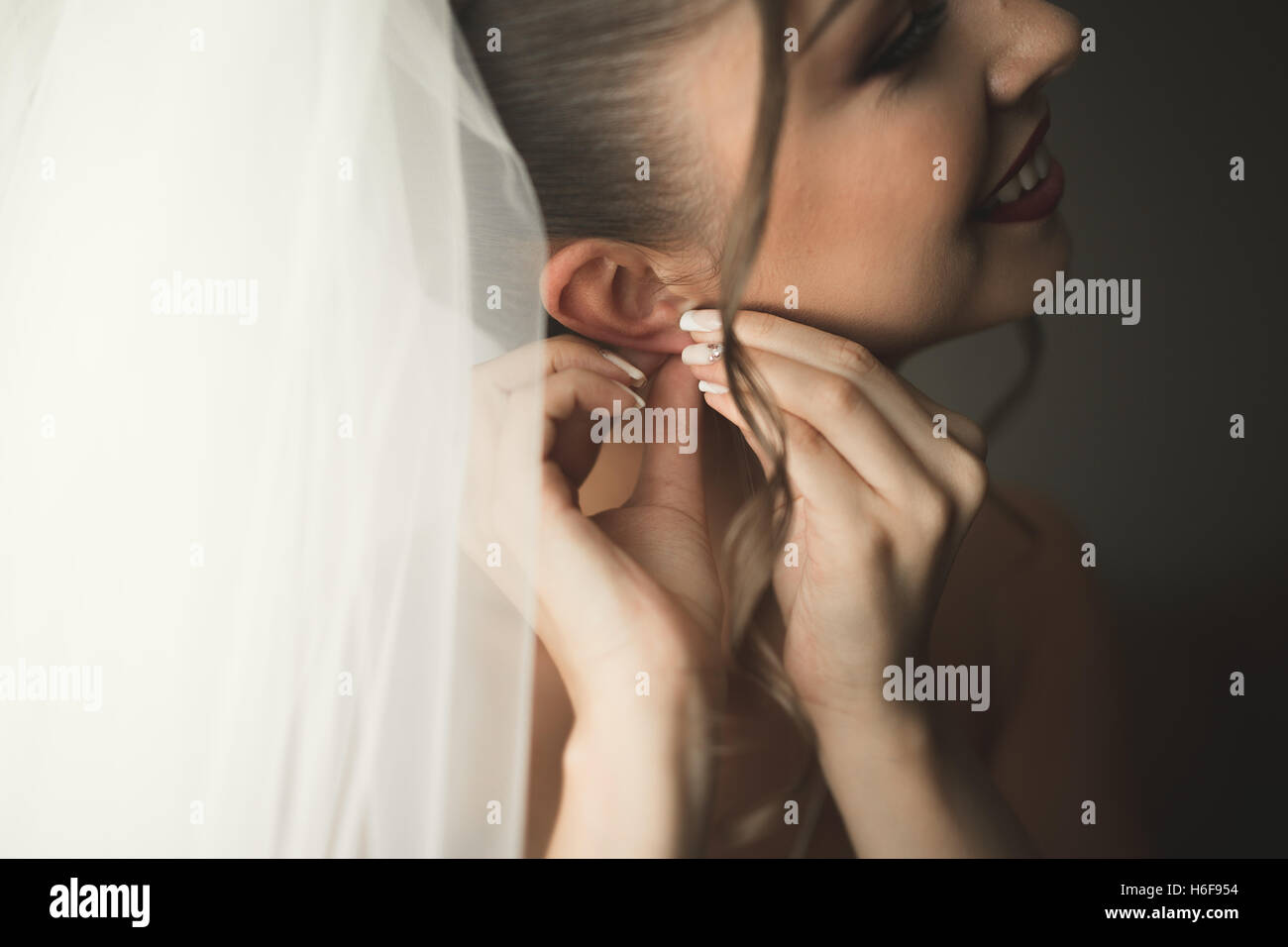 Sposa di lusso in abito bianco in posa durante la preparazione per la cerimonia di nozze Foto Stock