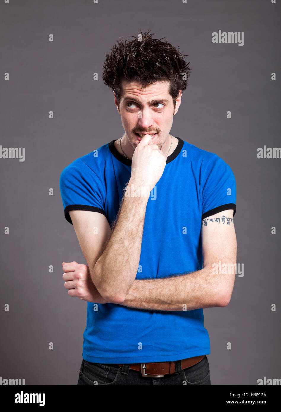 Ritratto in studio di un giovane adulto uomo caucasico goofing off nella parte anteriore della fotocamera. Foto Stock