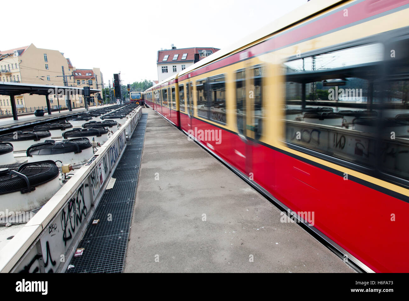 Treno in partenza un urbano stazione ferroviaria piattaforma in Berlino, con una lunga fila di ventilatori che fanno circolare l'aria per la undergr Foto Stock