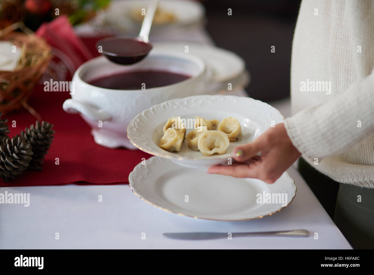 Donna versando tradizionale zuppa di barbabietole Foto Stock