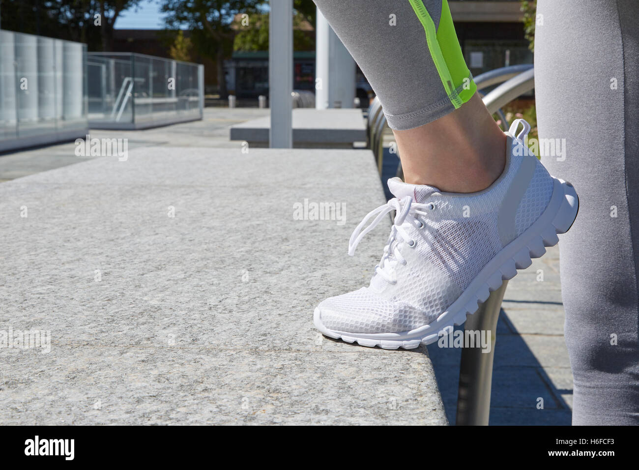 Donna con il bianco scarpe da corsa prima di allenamento nella città Foto Stock