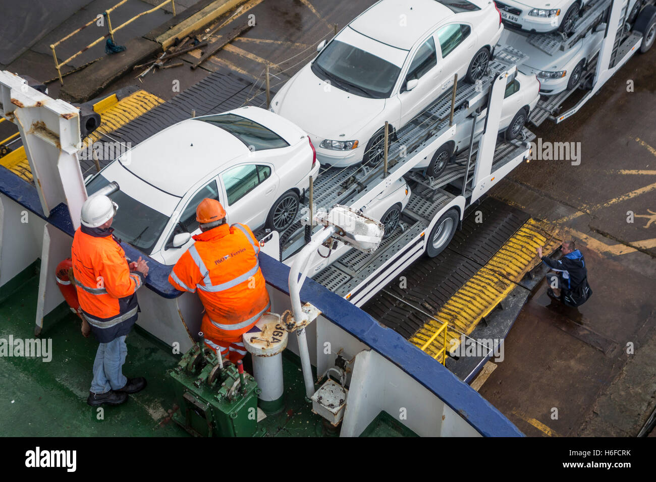 Nave di membri di equipaggio guardare carrello con vetture su auto vettore rimorchio imbarco ferry boat di P&O North Sea Ferries Foto Stock