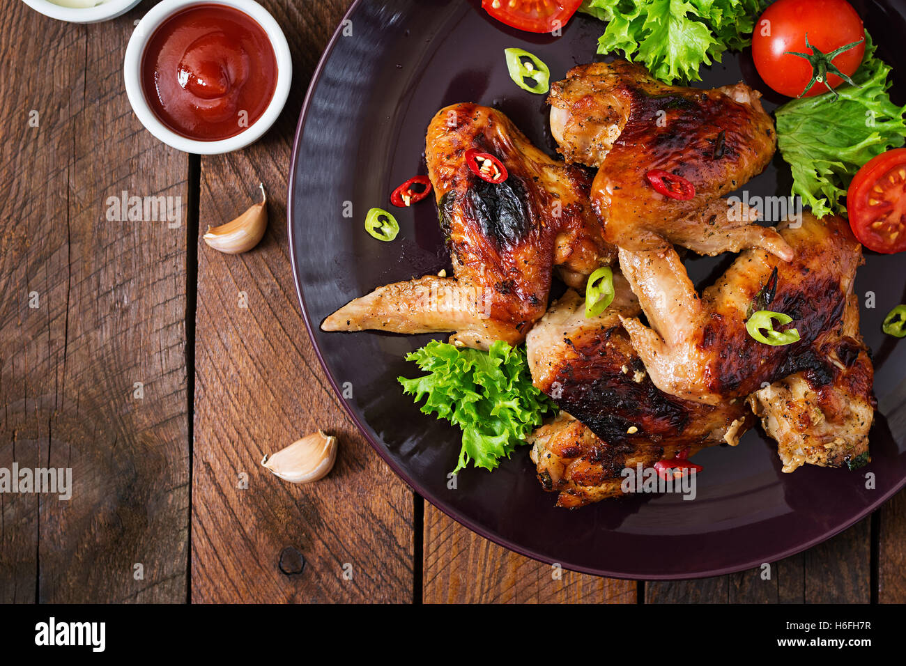 Cotto al forno ali di pollo in stile asiatico sulla piastra. Vista superiore Foto Stock