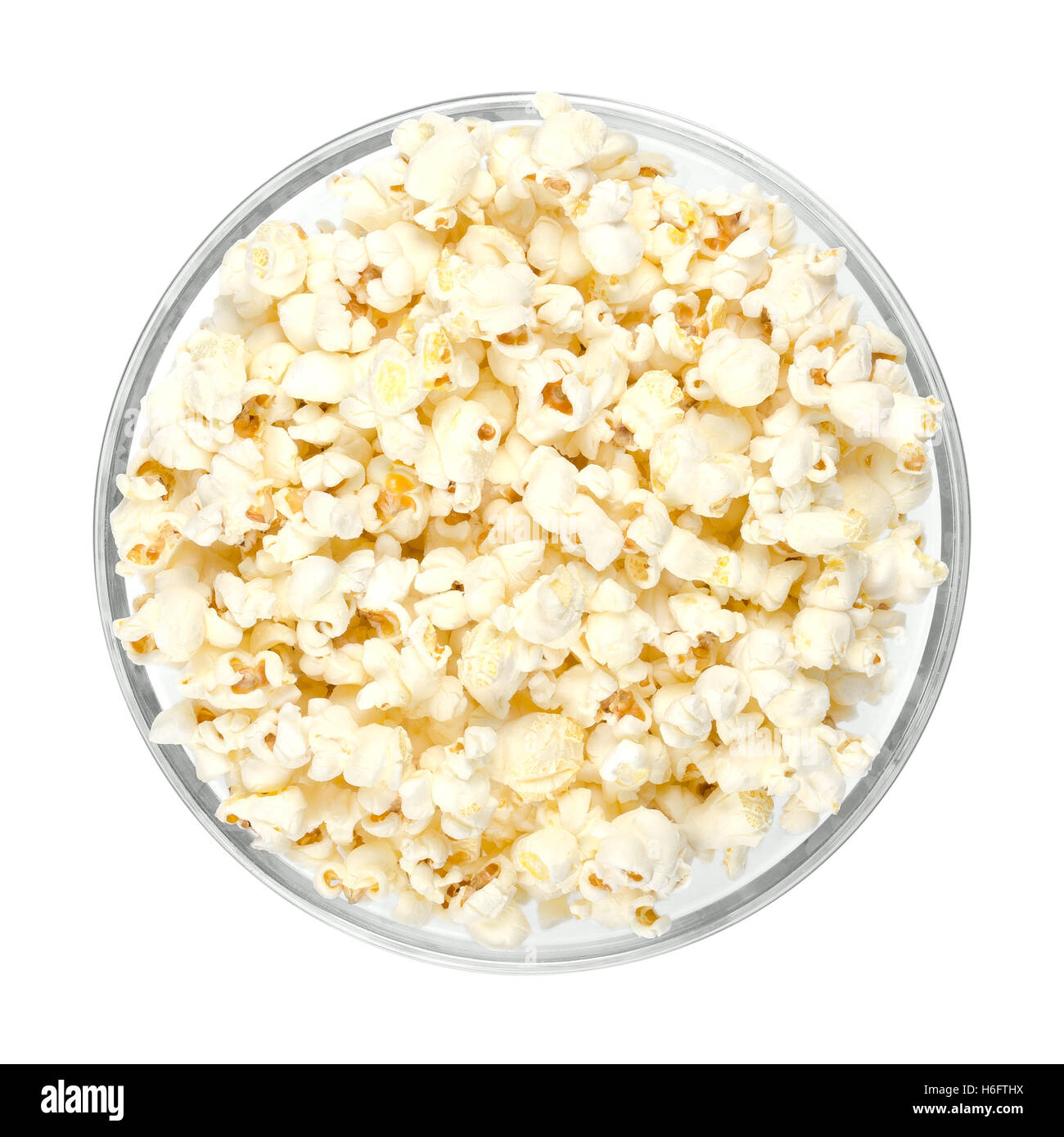 Popcorn schioccato in recipiente di vetro su sfondo bianco. A forma di farfalla di popcorn gonfiati dal kernel, dopo che è stato riscaldato. Foto Stock