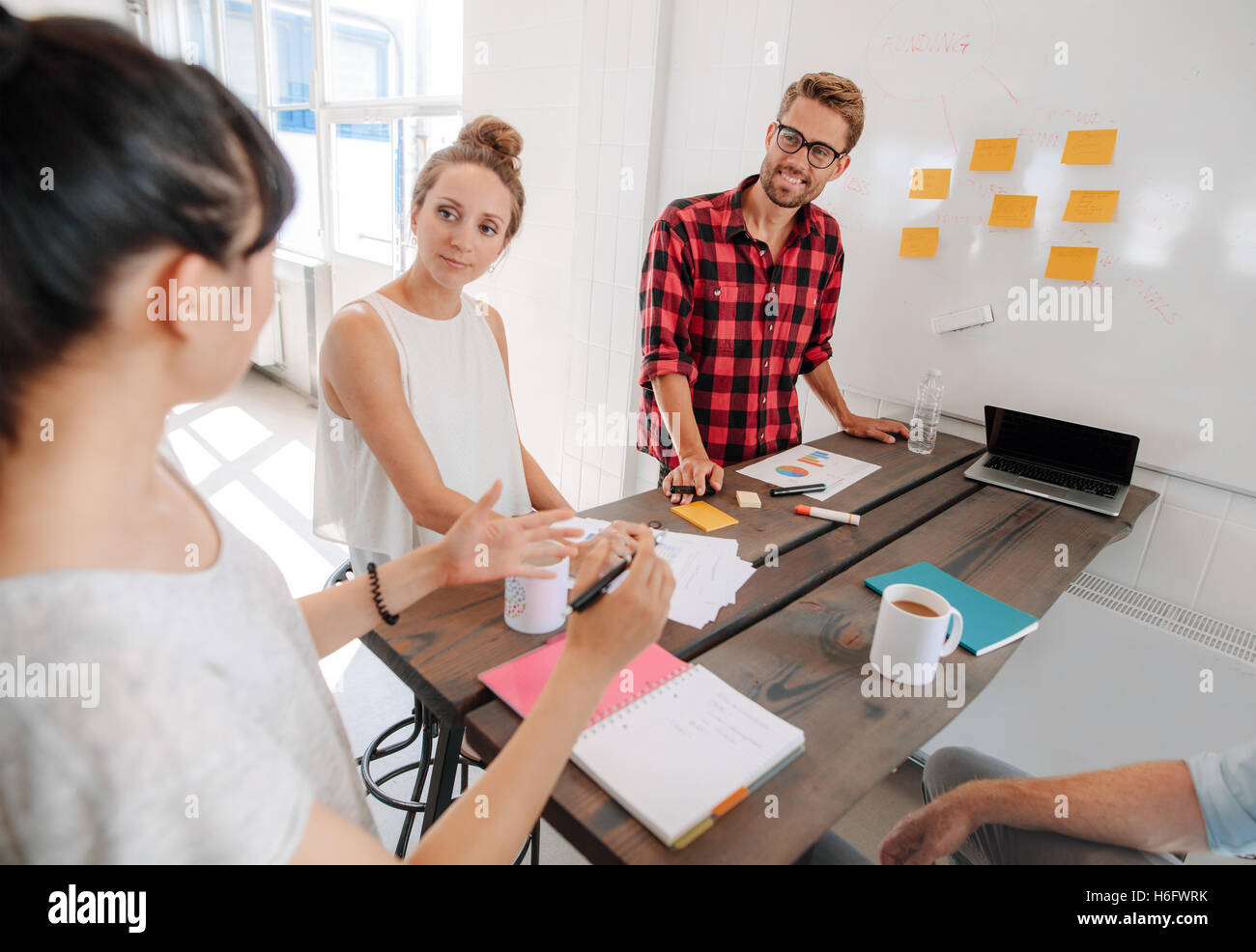 Shot gruppo di diverse persone di affari di discutere in una sala riunioni presso il creative office. I colleghi di avvio di brainstorming busine nuovo Foto Stock