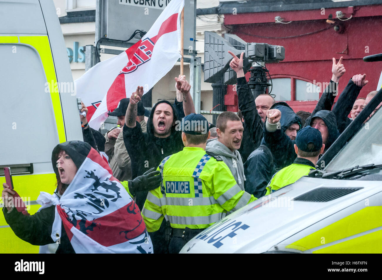 Membri della Difesa inglese League marzo a Brighton, protetti dalla polizia e rivolta verso l'opposizione locale. Foto Stock