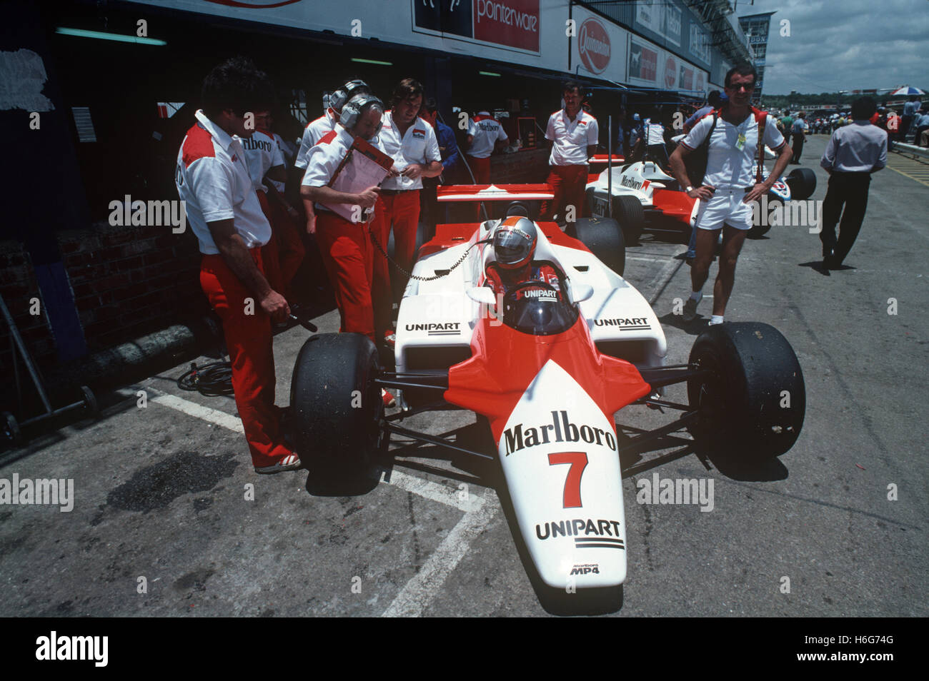 John Watson in Formula 1 McLaren con il team in box Foto Stock