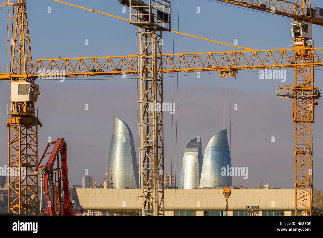 Gru edili contro uno sfondo di torri a fiamma, Baku, Azerbaijan Foto Stock