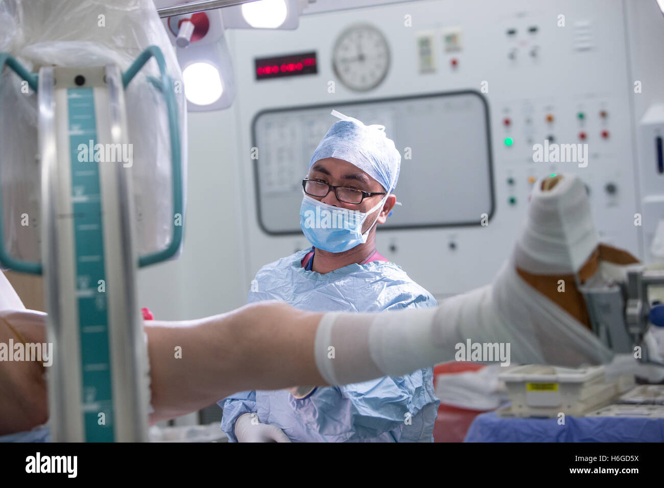 Un chirurgo e staff preparare il paziente per la chirurgia prima di effettuare una riduzione aperta e la fissazione interna di una caviglia sinistra Foto Stock