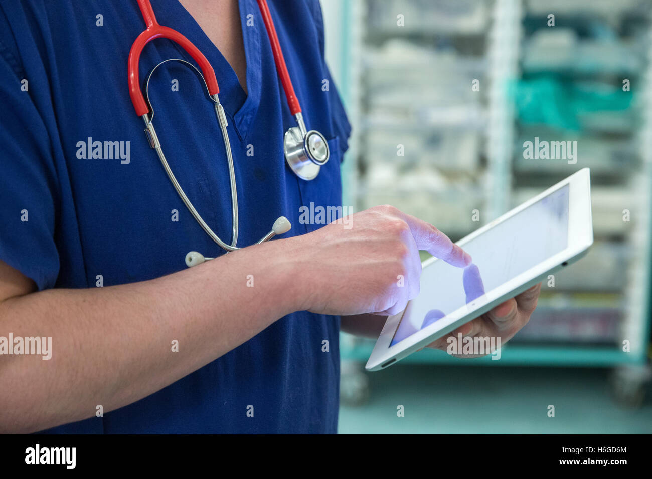 Un medico su una ward controlli a pazienti' registra su un Ipad Foto Stock