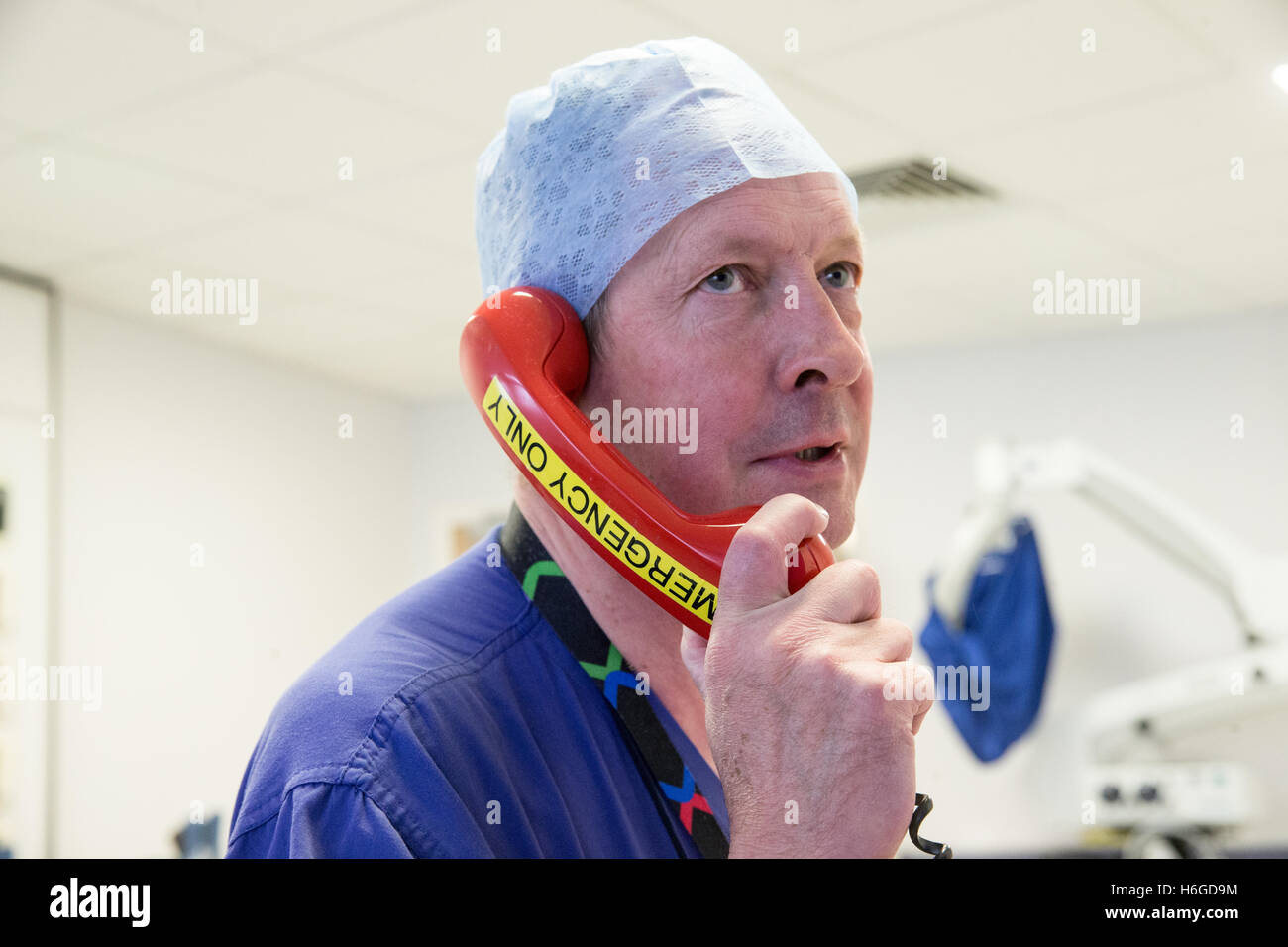 Un medico in ospedale utilizza il telefono di emergenza ad anello per assistenza Foto Stock