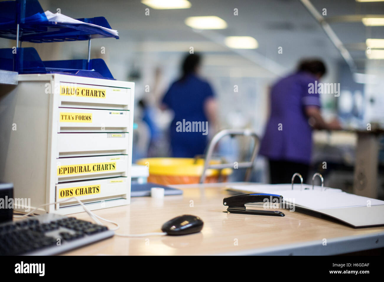 Foto di workstation che mostra i cassetti di farmaco in un ospedale con i pazienti e il personale in background Foto Stock