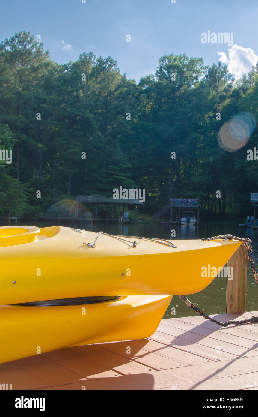 Giallo Kayak seduti sul dock sul fiume Foto Stock
