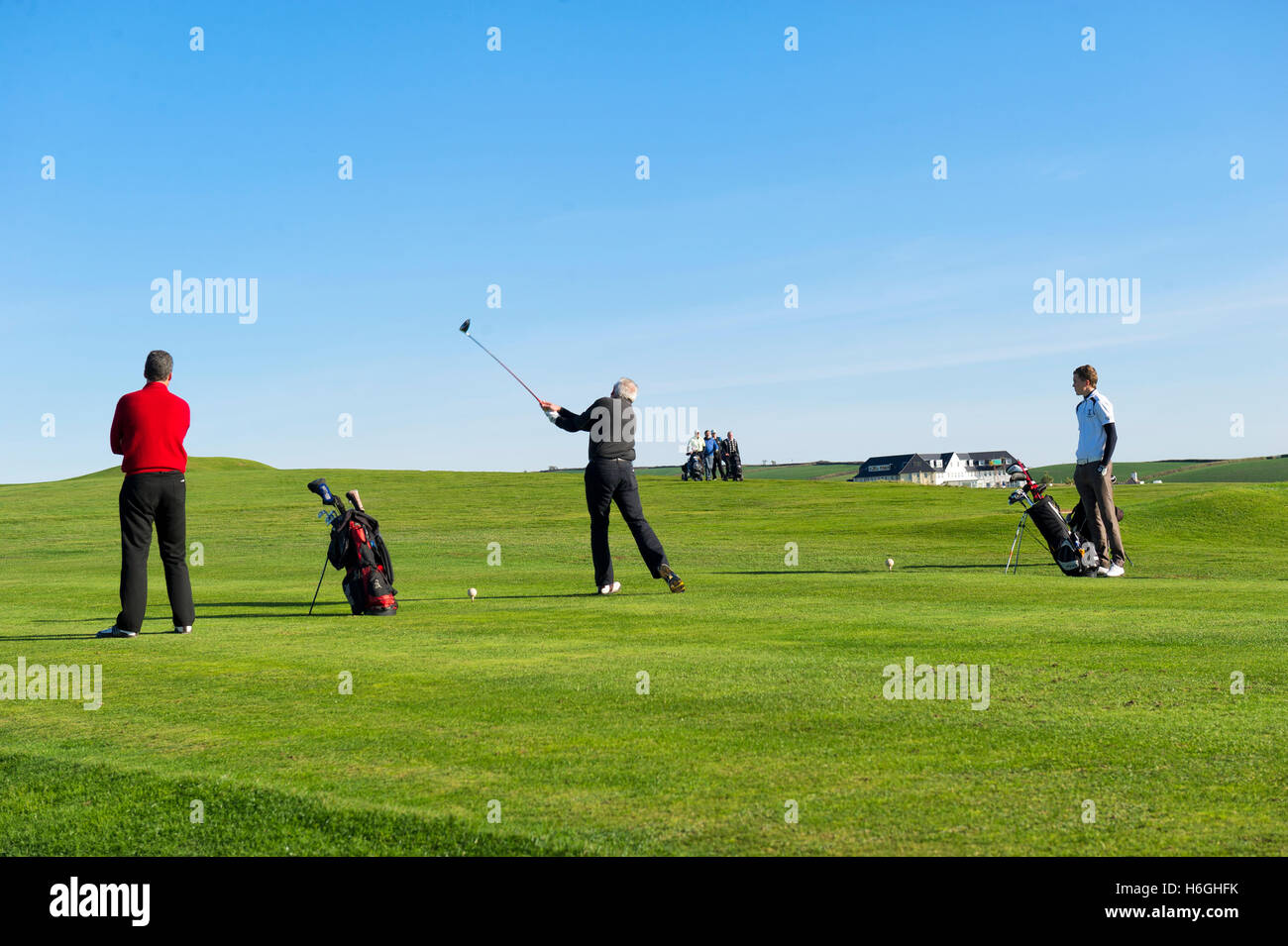 Gli amanti del golf a giocare a thurlestone golf club, devon su un giorno d'estate contro un cielo blu chiaro Foto Stock