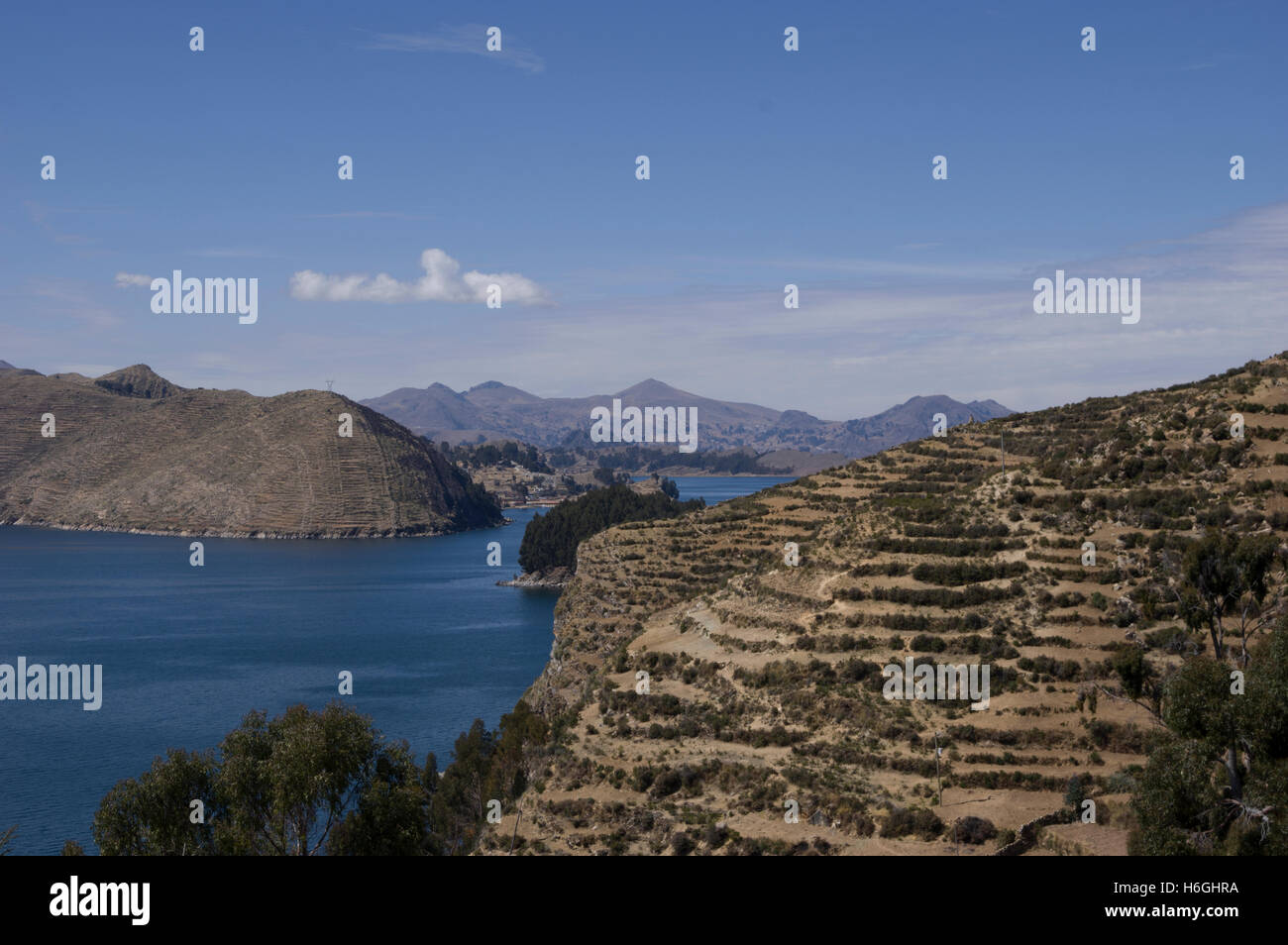 Il lago Titicaca con un cielo blu, il bianco delle nuvole, picchi di montagna, isole Foto Stock