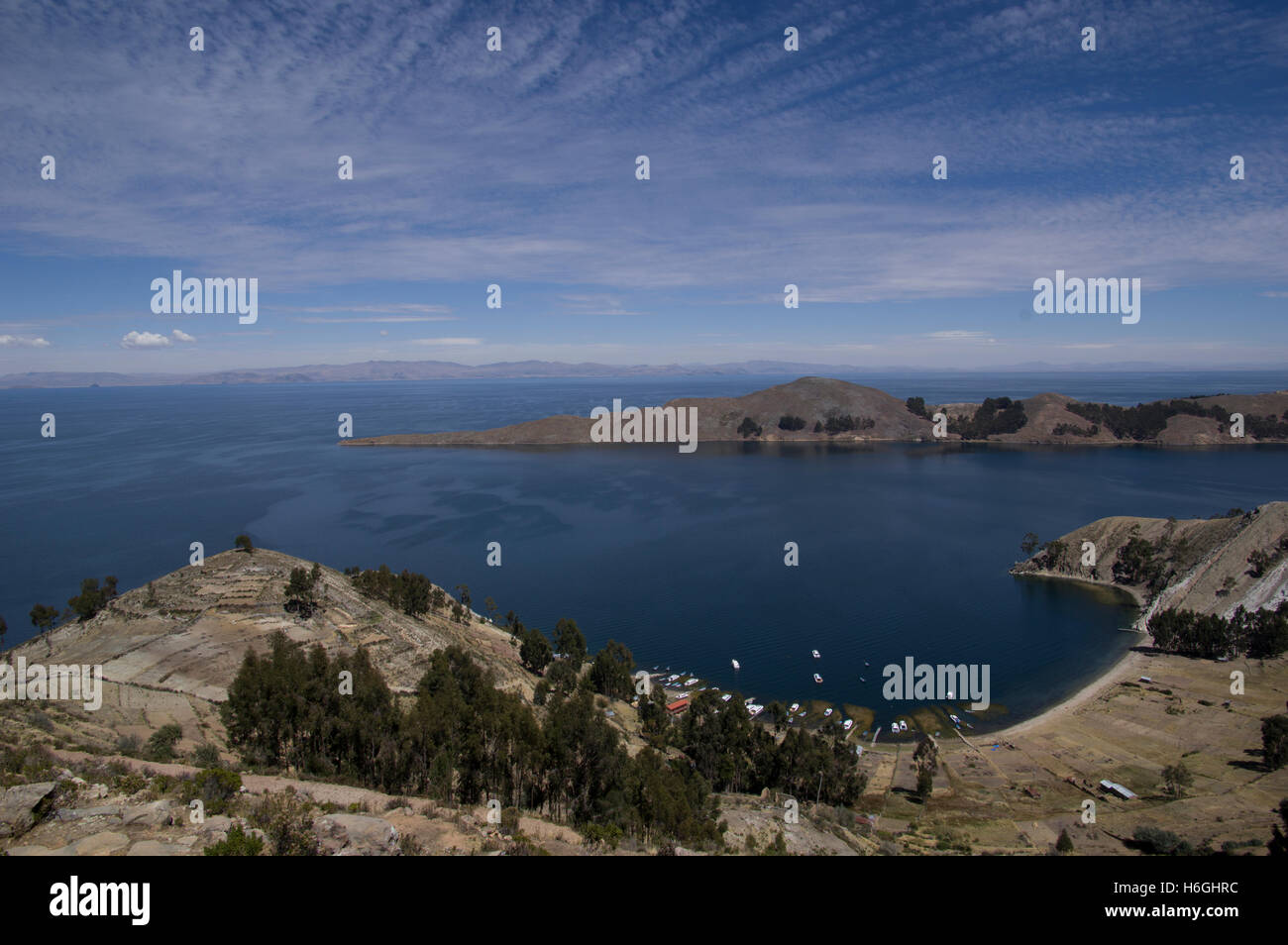 Il lago Titicaca con un cielo blu, il bianco delle nuvole, picchi di montagna, isole Foto Stock