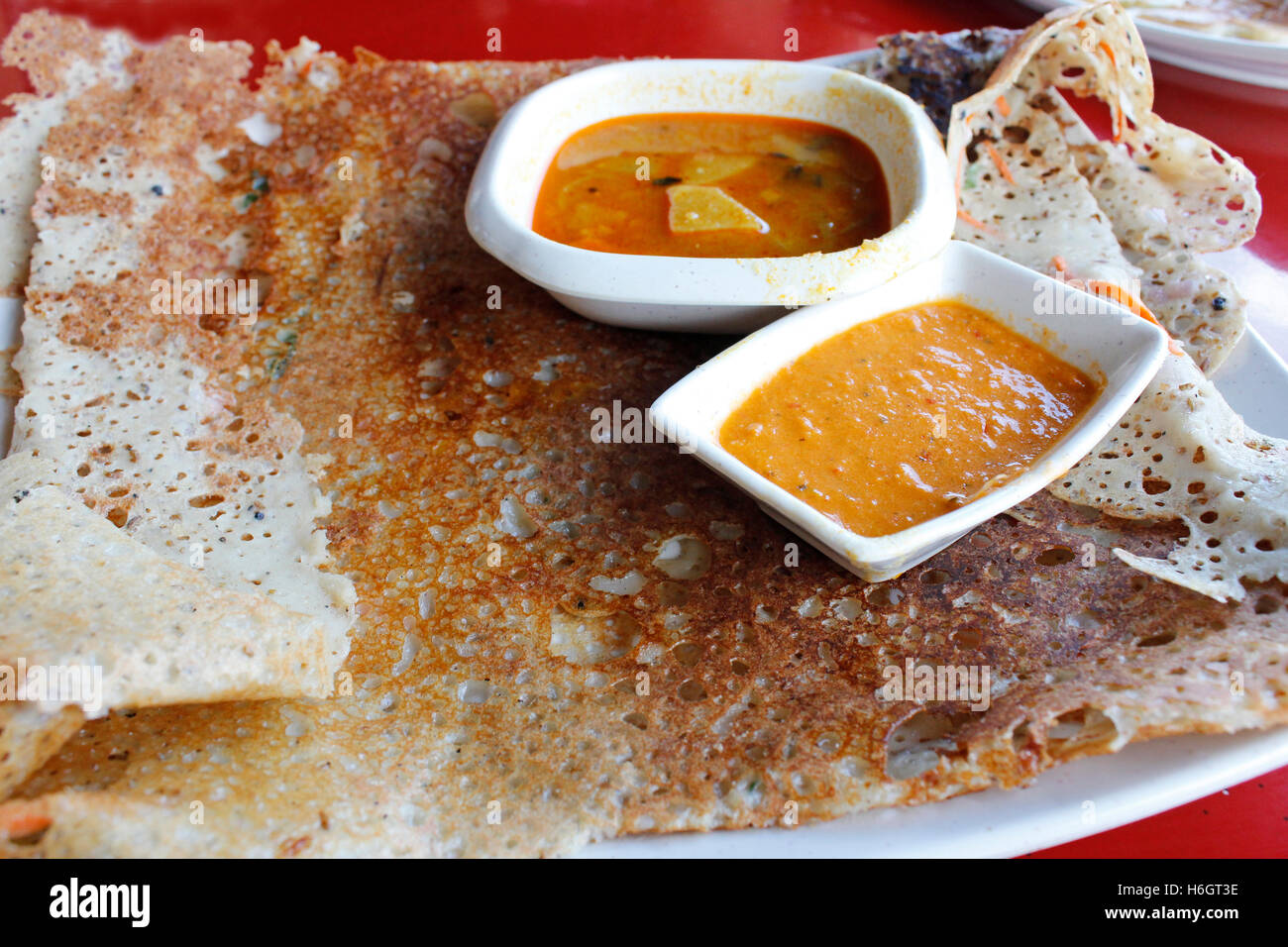 Rava dosa o Ravvattu o Rave Dose, è un Indiano crêpe dell India del Sud servire con curry e salsa di peperoncino Foto Stock