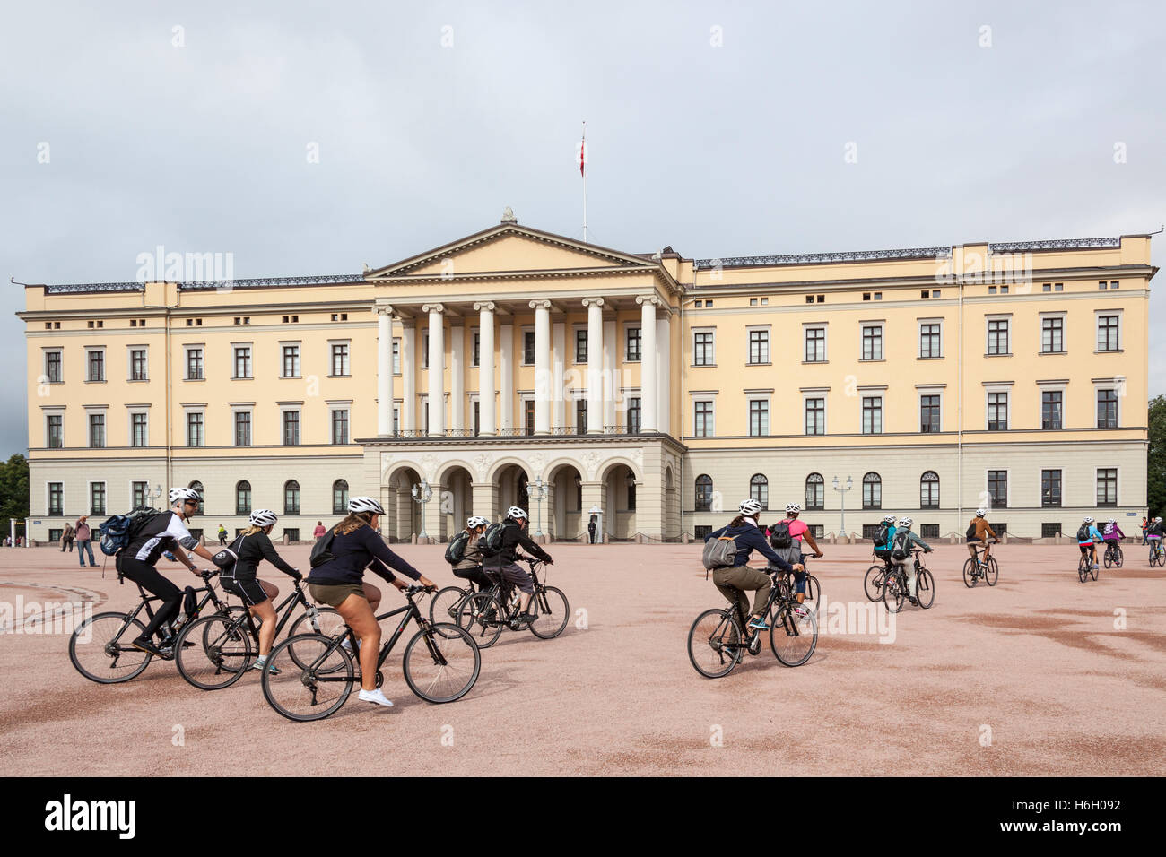 I ciclisti pedalando attraverso il Royal Palace, Det Kongelige Slott, Oslo, Norvegia Foto Stock