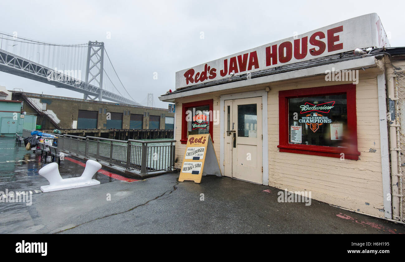 Rossi Casa Java, sull'Embarcadero in San Francisco, siede sotto la pioggia con il ponte della baia in background. Foto Stock