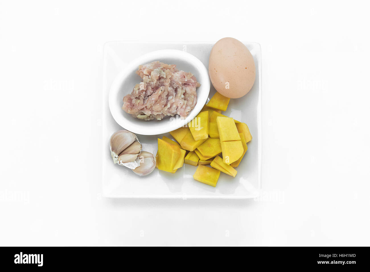 Alimenti crudi di zucca fritti, carne di maiale e uova Foto Stock