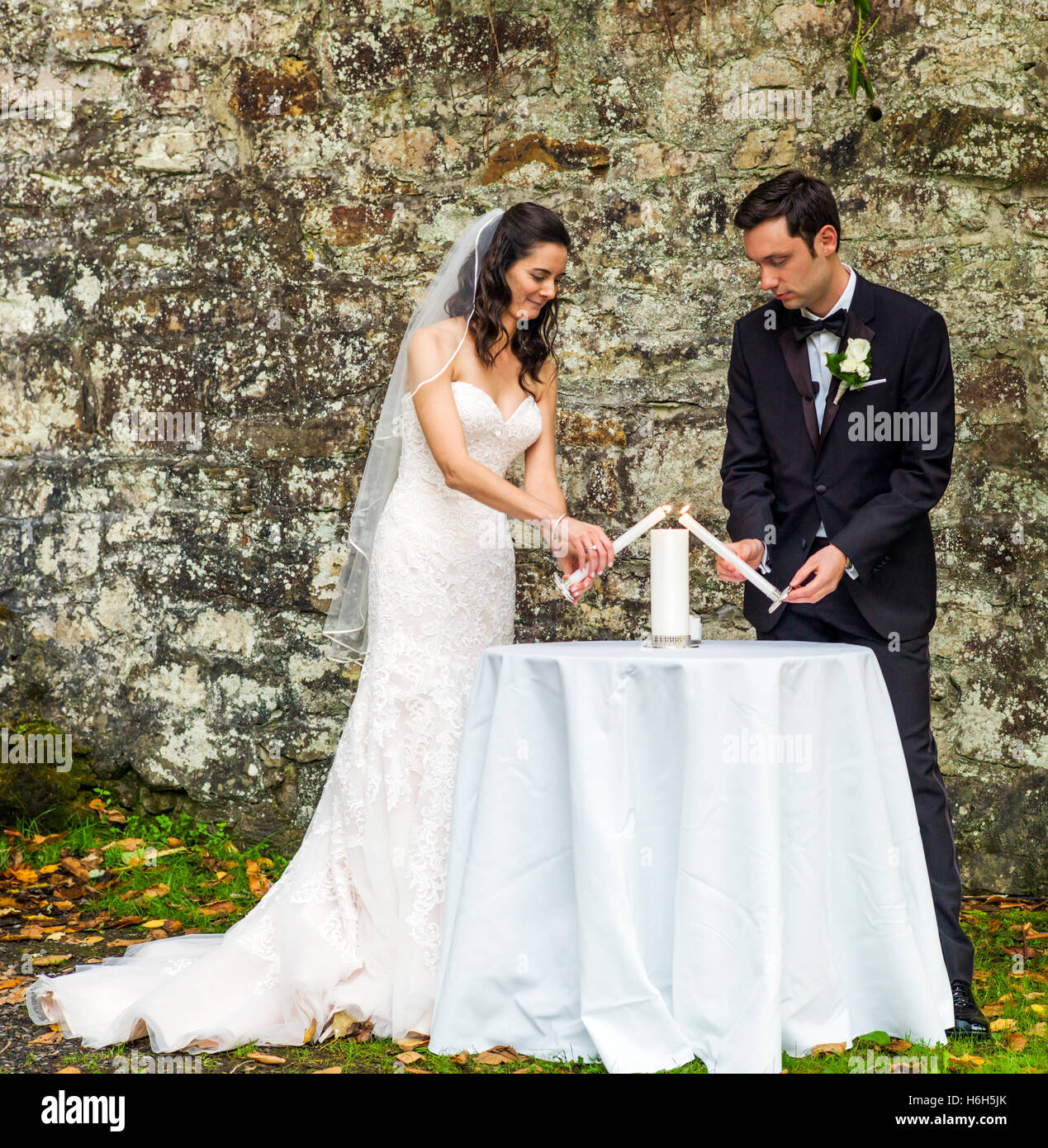 Sposa e lo sposo prendendo i voti di nozze & luce candele; giardino esterno cerimonia; Omni Bedford Springs Resort & Spa; Bedford; PA Foto Stock