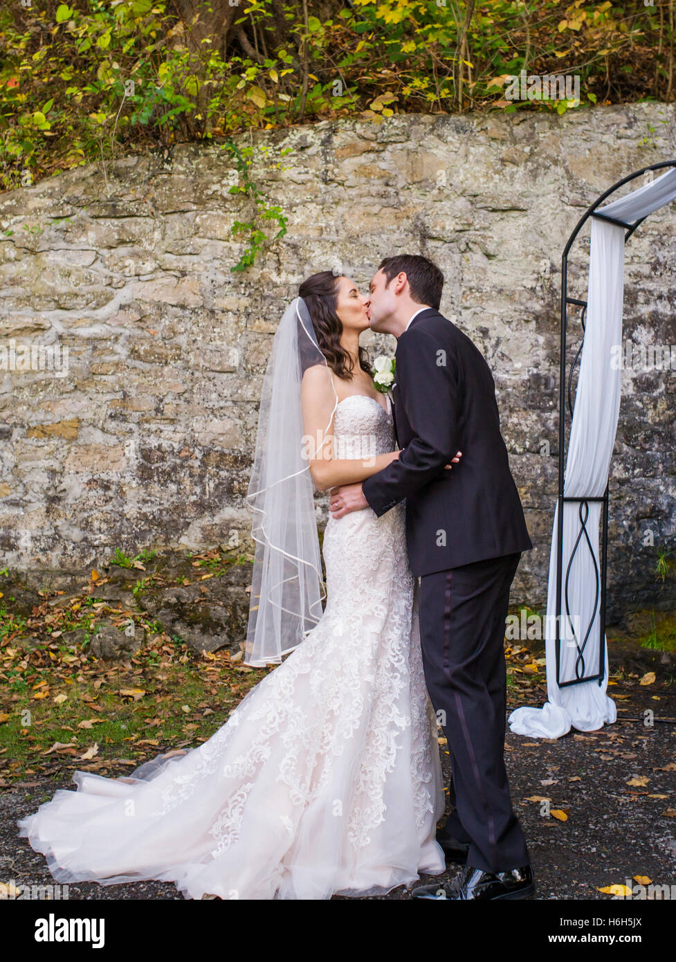 Sposa e lo sposo kiss durante le cerimonie voti; giardino esterno cerimonia; Omni Bedford Springs Resort & Spa; Bedford; Pennsylvania; USA Foto Stock