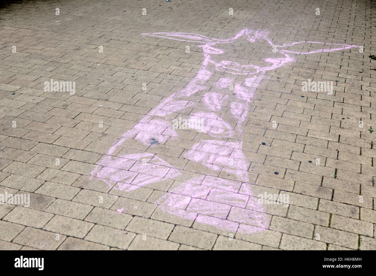 Chalk disegno di una giraffa sulla via di un parco urbano. Foto Stock