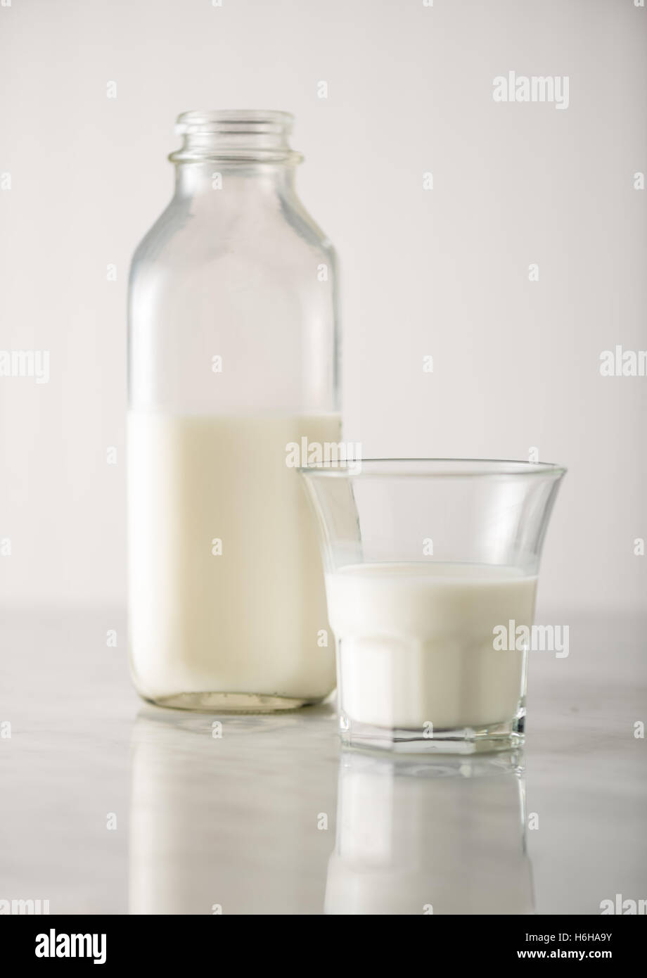 Bicchiere di latte bianco con bottiglia sul bianco. Un sacco di spazio di copia Foto Stock