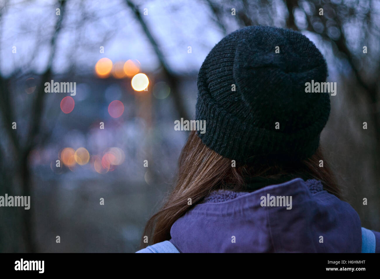 Vista posteriore del giovane donna guardando il paesaggio urbano sfocata Foto Stock