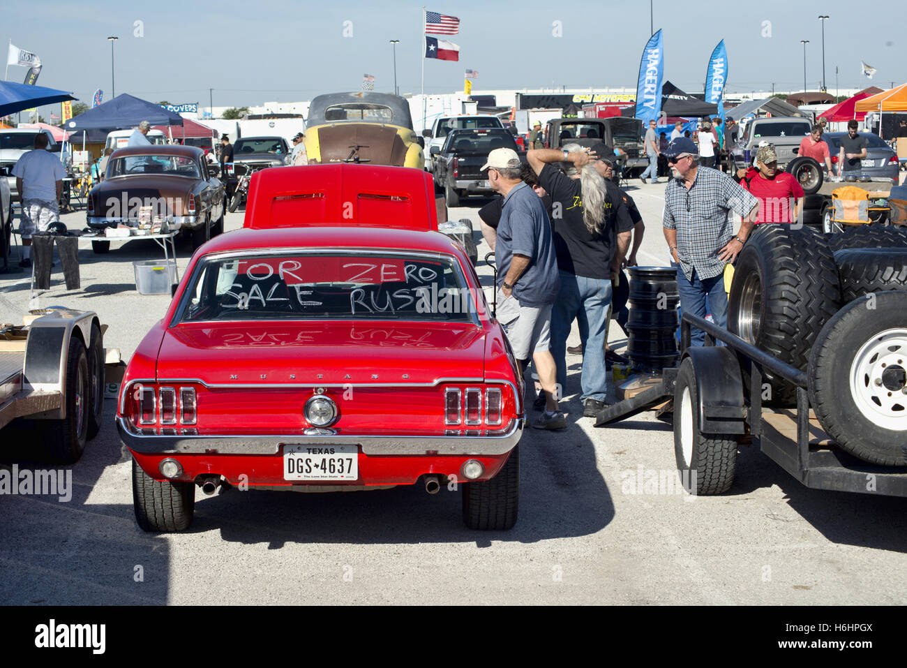 Grand Prairie, Texas- Ott.29,2016 automobili per la vendita a livello locale auto swap meet. persone che guardano un rosso 1966 Ford Mustang. Foto Stock
